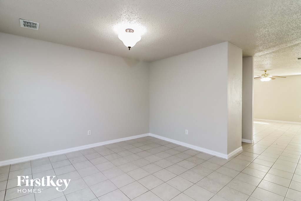 A spacious empty room with a FirstKey Homes logo on the bottom left.