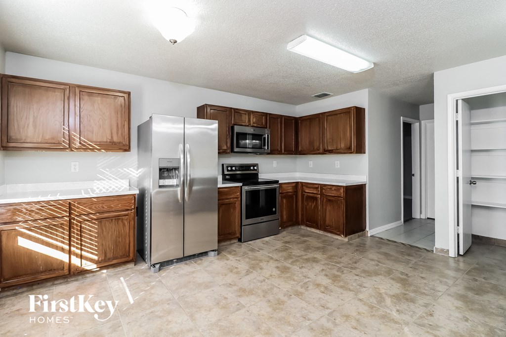 A kitchen with wooden cabinets and a refrigerator.