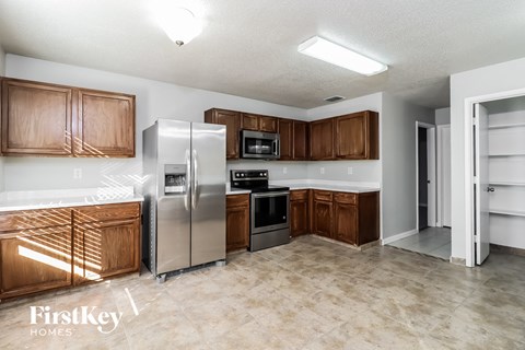 A kitchen with wooden cabinets and a refrigerator.
