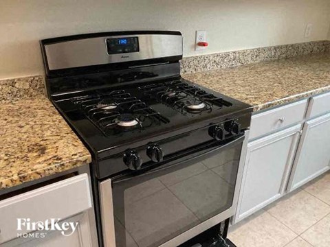 a stainless steel stove in a kitchen with white cabinets