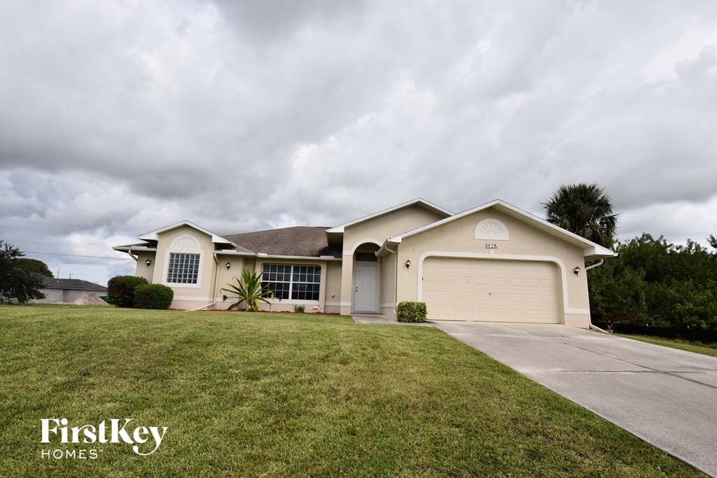 a beige house with a garage and a lawn