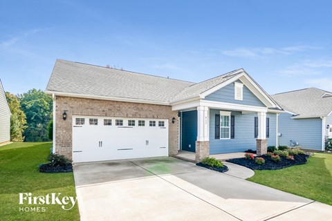 a blue house with a white garage door and a lawn