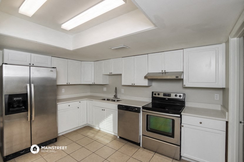 a kitchen with white cabinets and stainless steel appliances