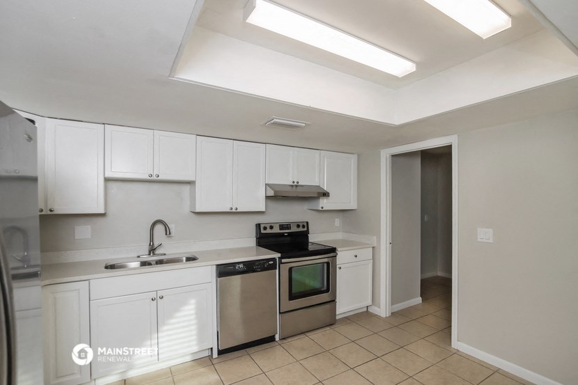 a kitchen with white cabinets and stainless steel appliances