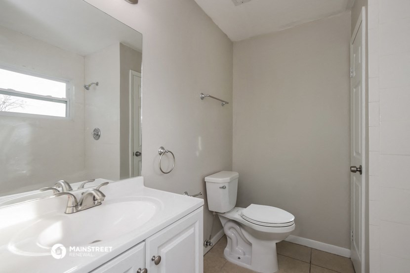 a bathroom with a sink toilet and a mirror