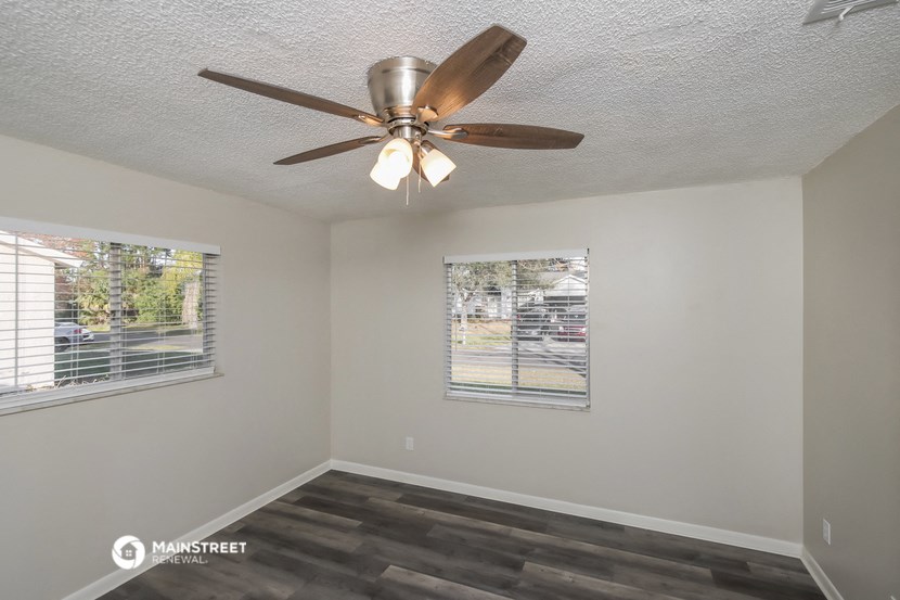 a living room with a ceiling fan and a window