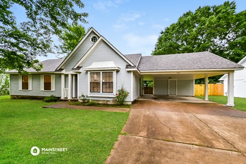 a white house with a driveway and a lawn