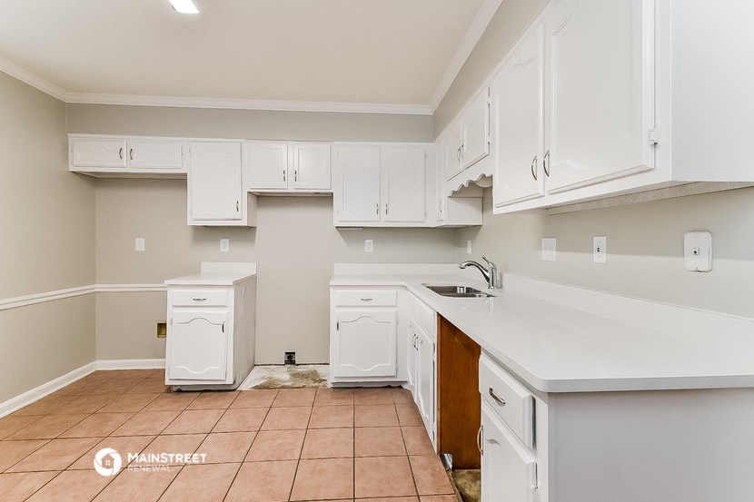a kitchen with white cabinets and white counters and a sink