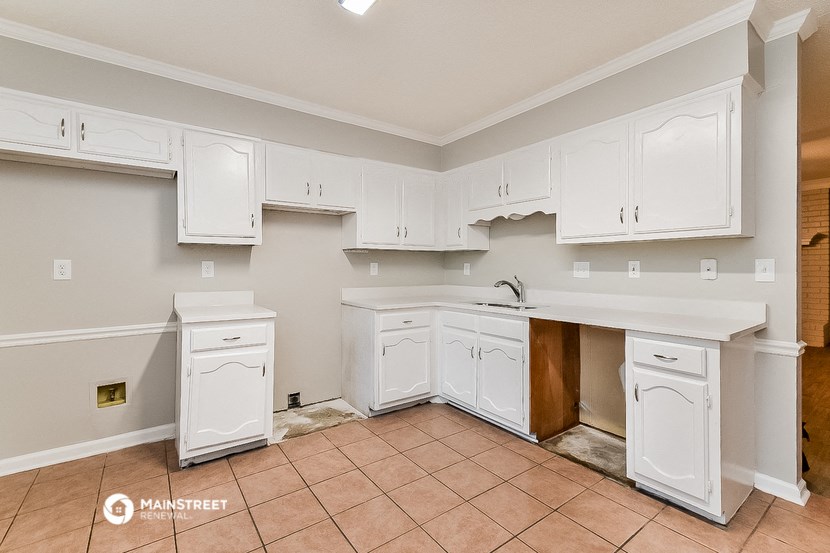 a kitchen with white cabinets and a sink and a counter