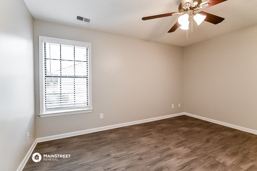an empty room with a ceiling fan and a window