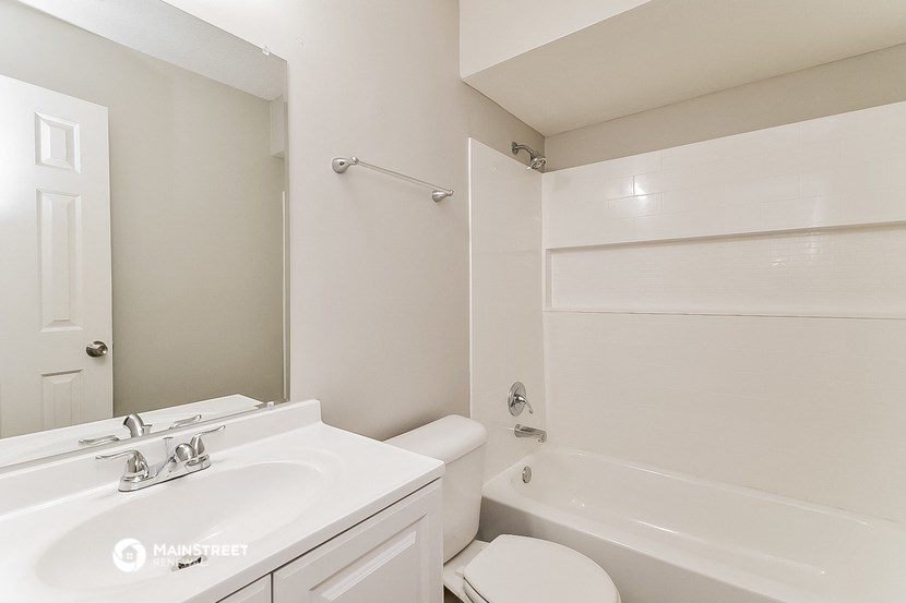 a white bathroom with a tub and a sink and a toilet