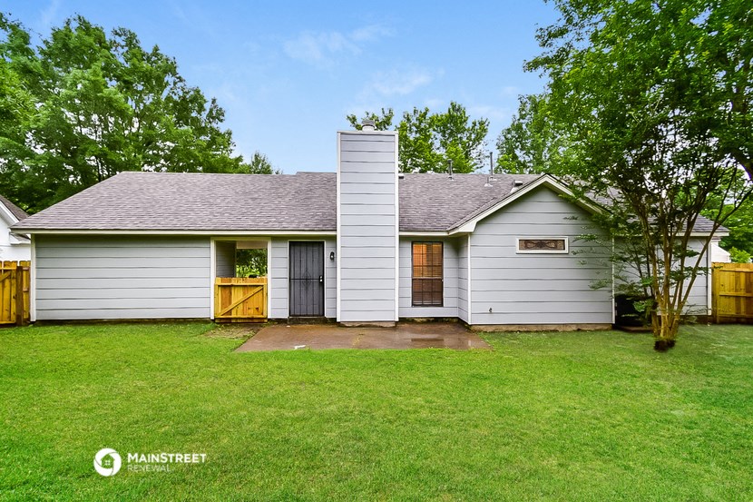 a white house with a yard and a wood fence