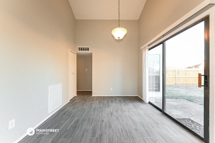 an empty living room with wood flooring and a large window