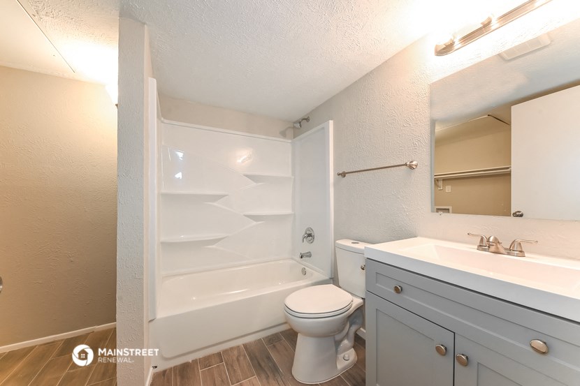 a bathroom with a toilet and a sink and a bath tub