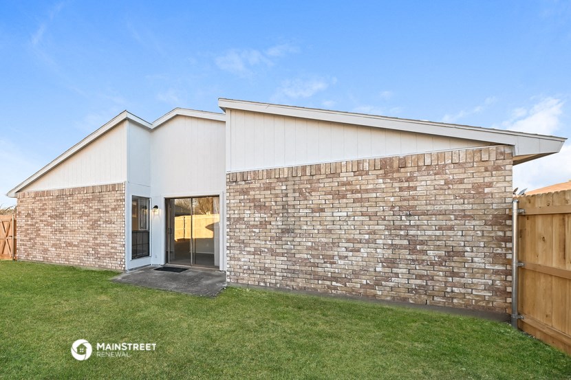 the exterior of a house with a brick wall and grass