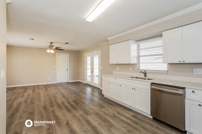a kitchen with white cabinets and a stainless steel dishwasher and a sink
