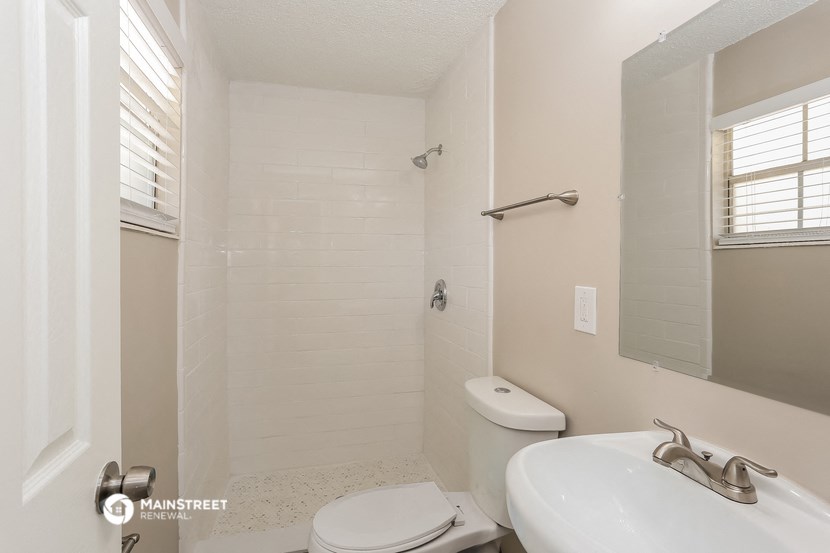 a white bathroom with a sink toilet and shower