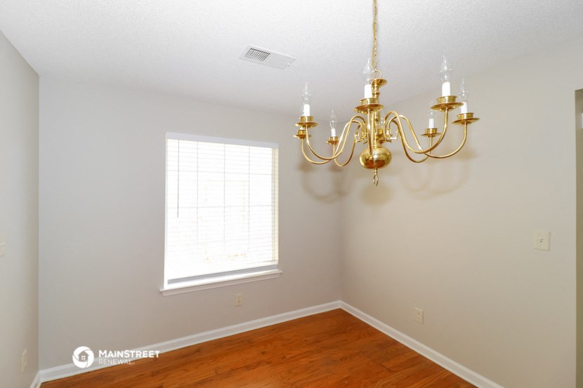 a dining room with a chandelier and a window