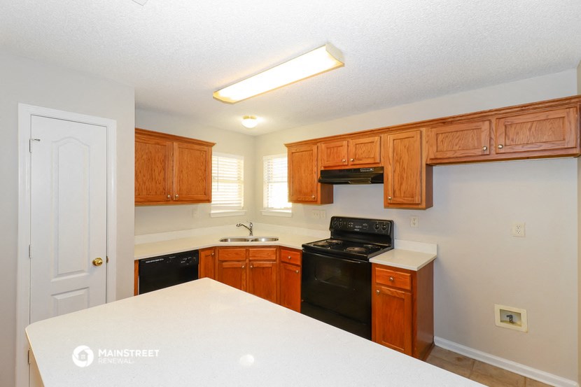 a kitchen with wood cabinets and black appliances and white counter tops