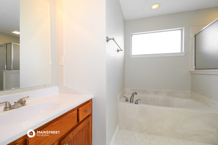 a bathroom with a tub and a sink and a mirror