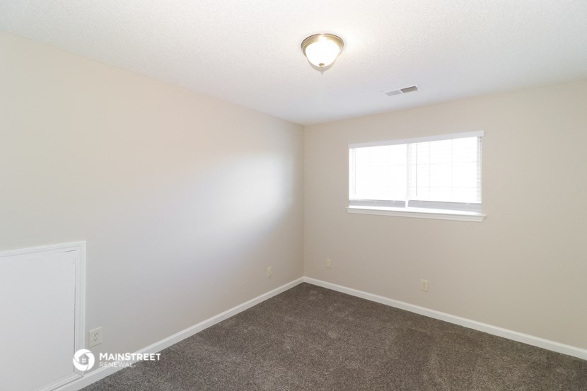 a empty room with carpet and a window
