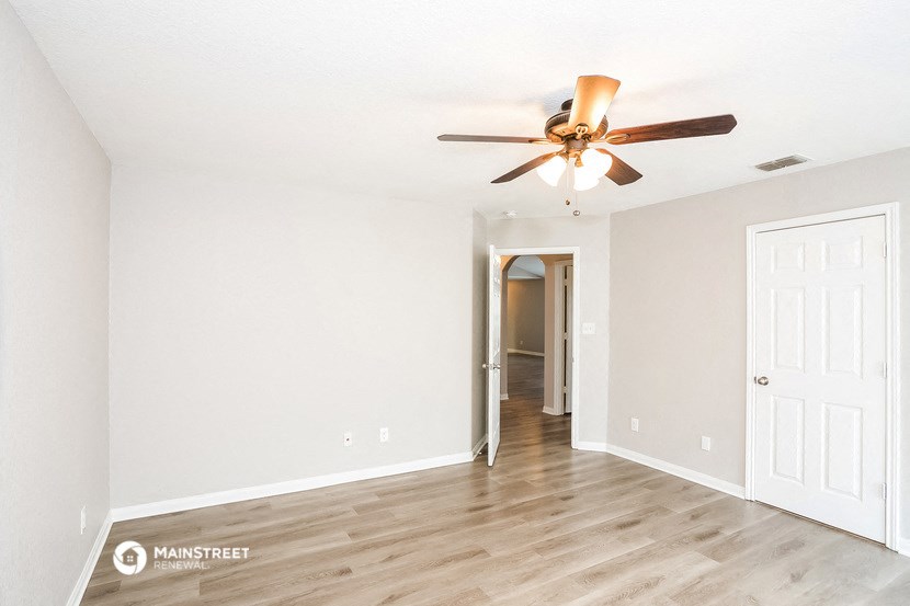the living room of an empty house with a ceiling fan