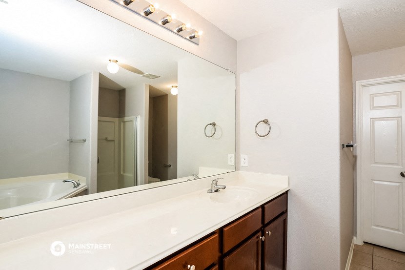a bathroom with a large mirror and a sink and a tub