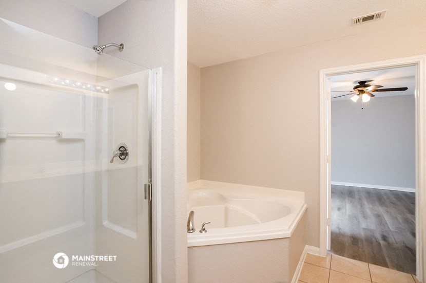 a bathroom with a tub and a shower and a closet