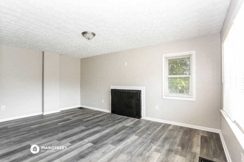 the spacious living room with wood flooring and a fireplace