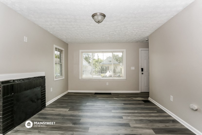the living room of a manufactured home with wood flooring and a large window