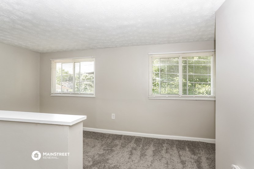 the living room of a small house with two windows