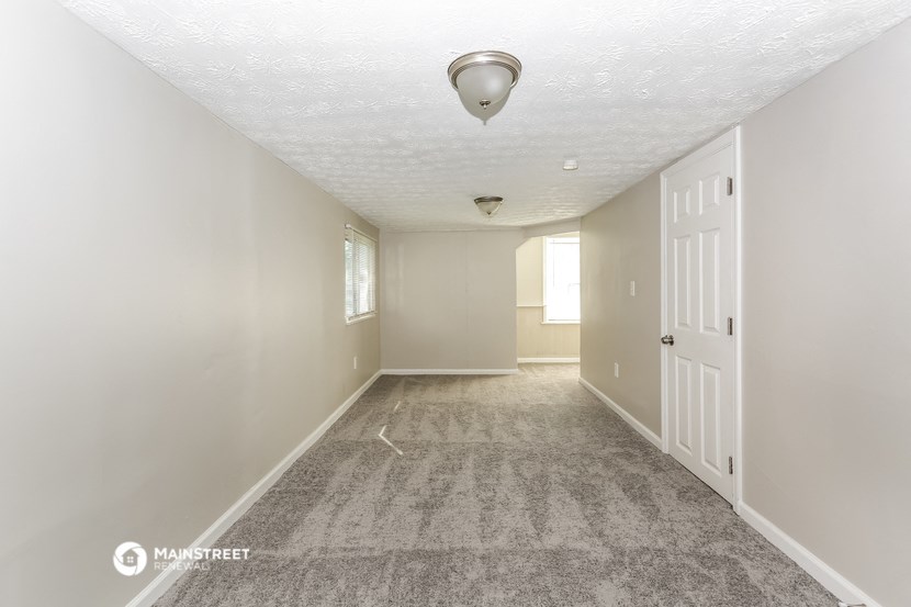 a empty room with a white door and a carpeted floor