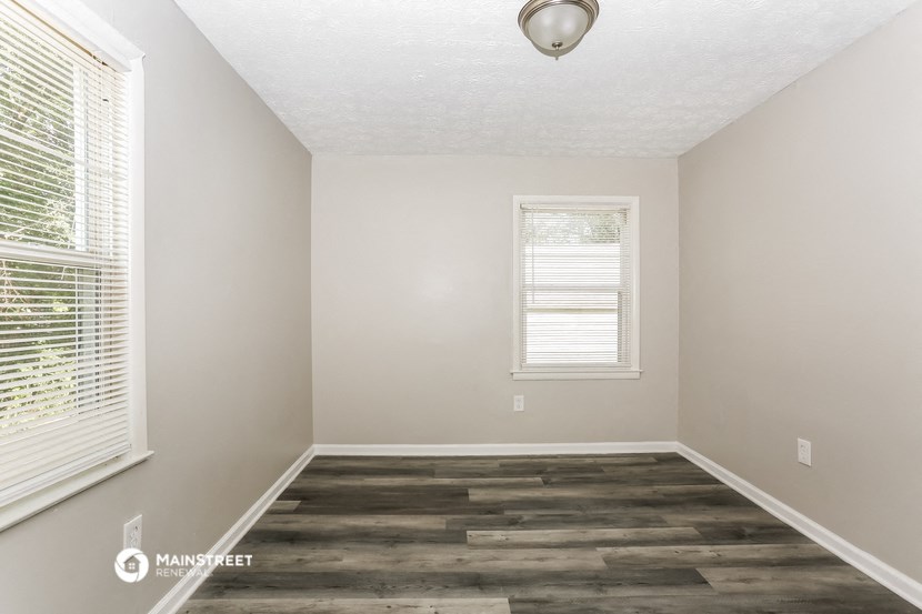 an empty room with wood floors and a window