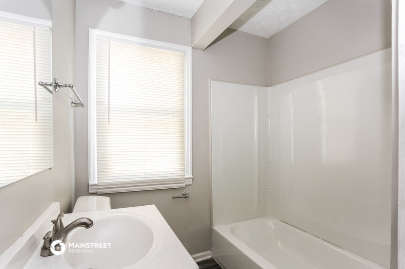 a bathroom with a sink and a bath tub and a window