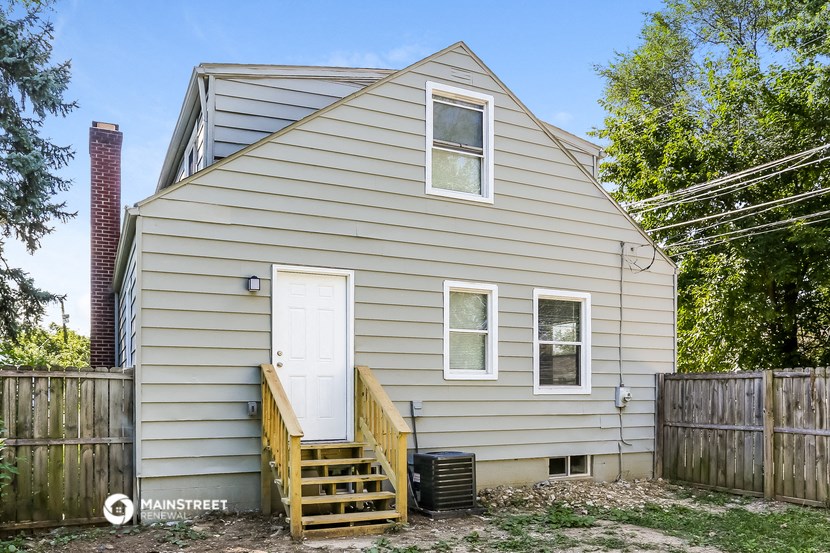 the outside of a house with stairs and a white door