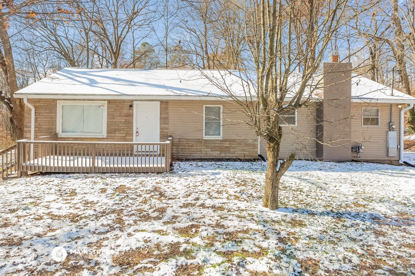a brown brick house with a white snow covered yard