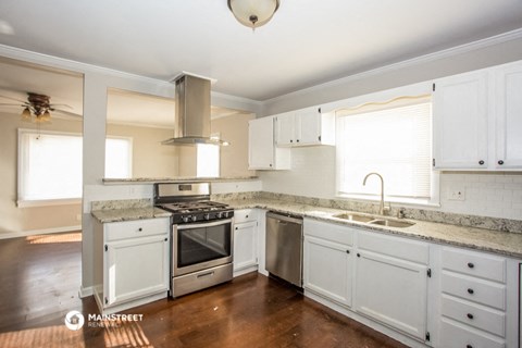 a kitchen with white cabinets and stainless steel appliances