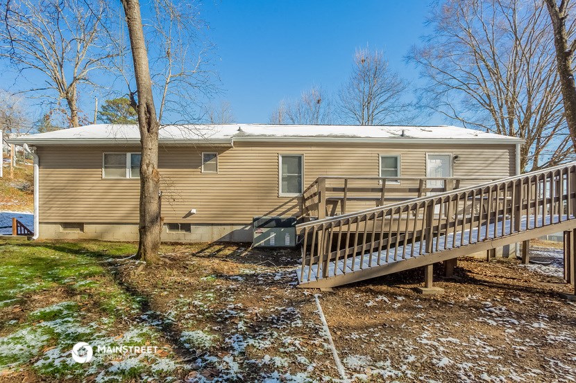 a yellow house with a porch and a deck