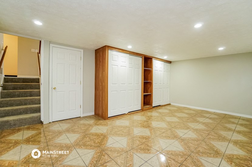 a empty living room with two doors and a staircase