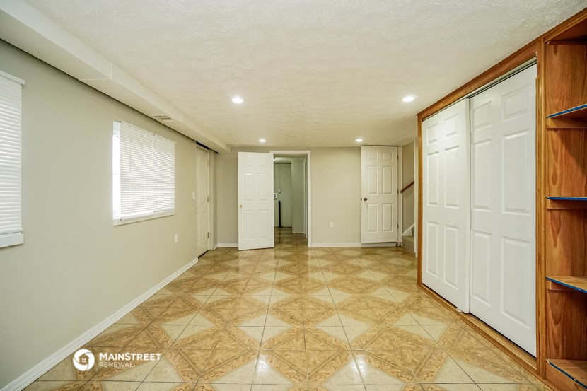 the living room and entryway of a house with white doors