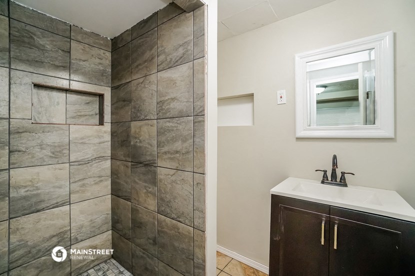 a bathroom with a shower and a sink and a mirror