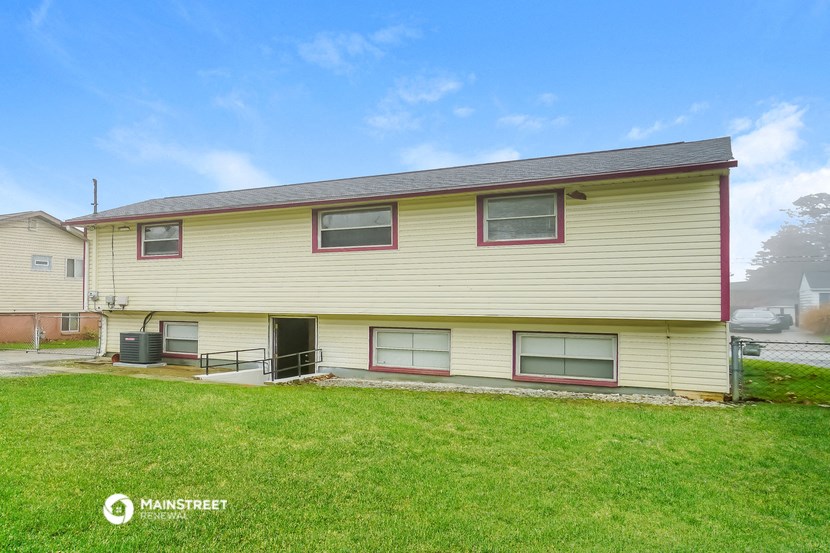 the front of a yellow house with a green lawn