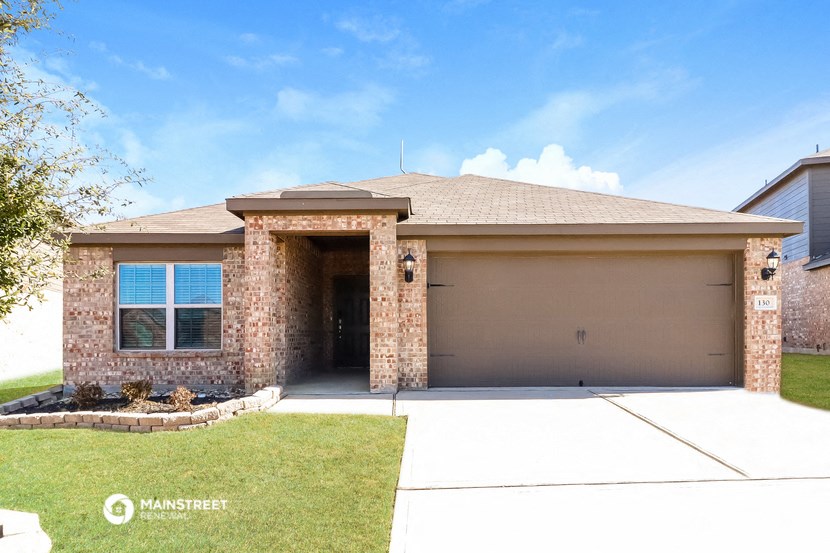front view of a brown house with a driveway and lawn