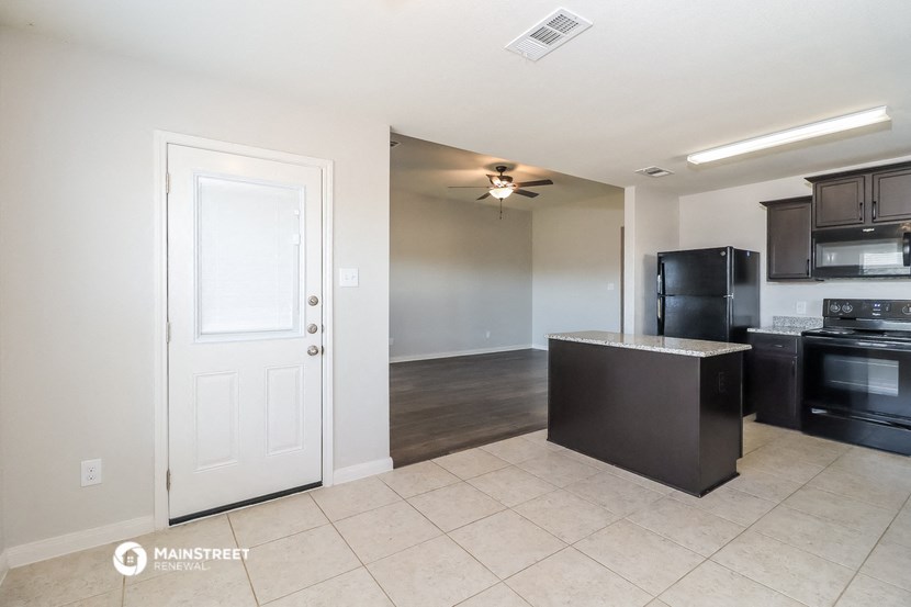 a kitchen and living room with a white door
