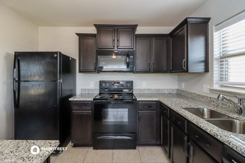 a kitchen with black appliances and granite counter tops