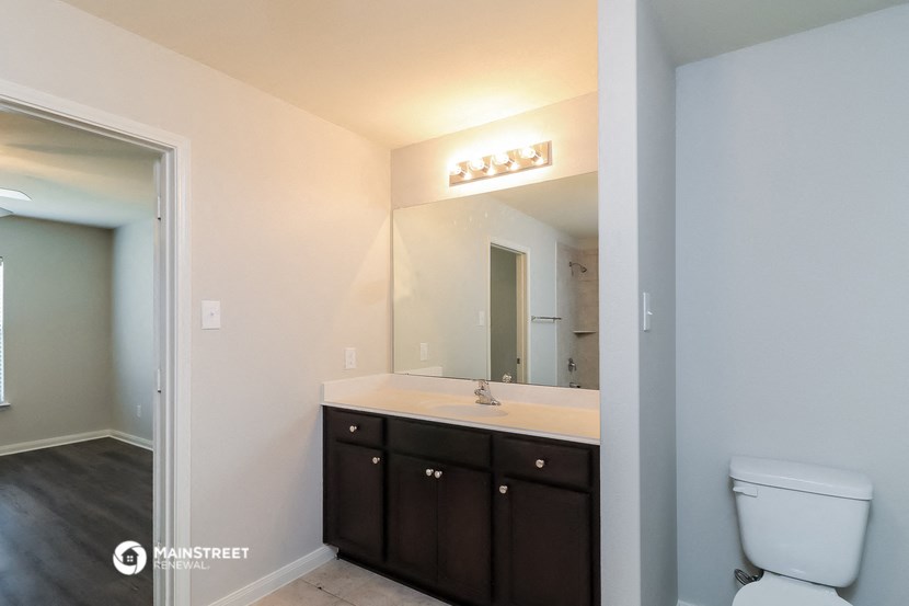 a bathroom with a toilet sink and a mirror