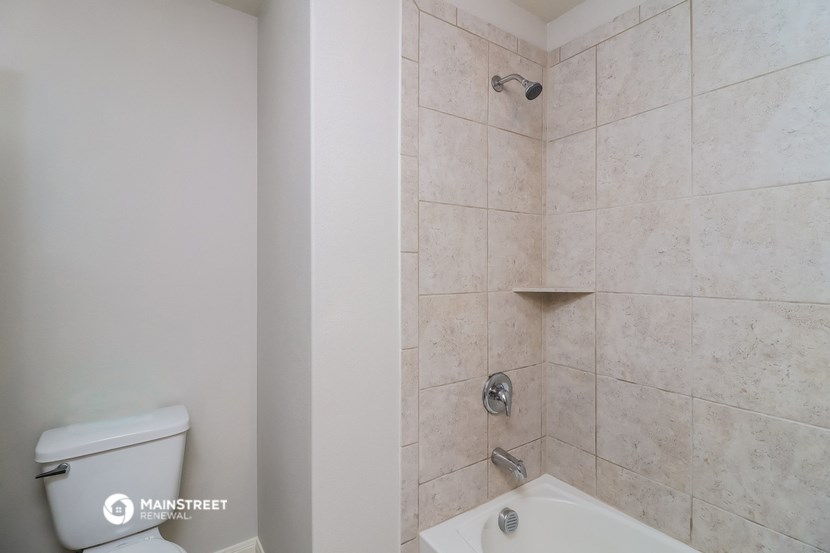 a bathroom with a shower and a toilet and a sink