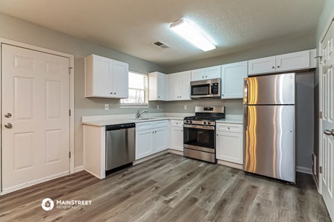 a kitchen with white cabinets and stainless steel appliances