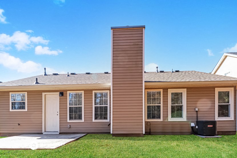 a tan house with a chimney on the side of it