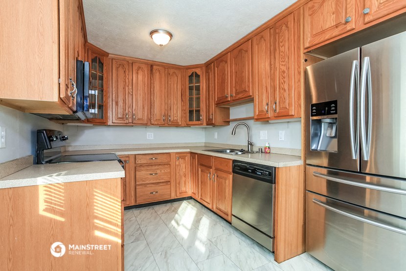 a kitchen with wooden cabinets and stainless steel appliances